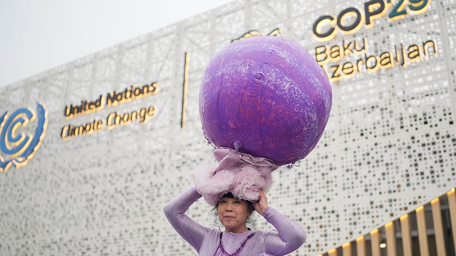 Chinese artist Kong Ning showcases her art installation "Purple Shells" that she says embodies the warming planet and polluted sea life, at COP29 on 18 November. 