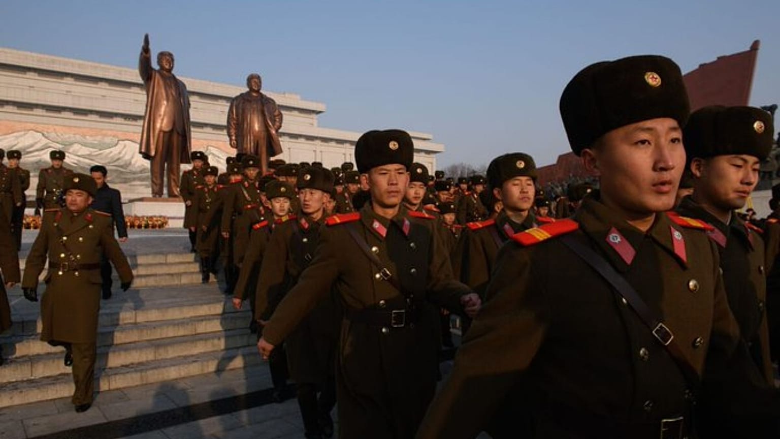 Észak-koreai katonák a két Kim-előd szobra előtt