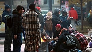 Des manifestants se réchauffent près d'un feu lors d'un rassemblement contre les résultats controversés des récentes élections parlementaires, à Tbilissi, en Géorgie.