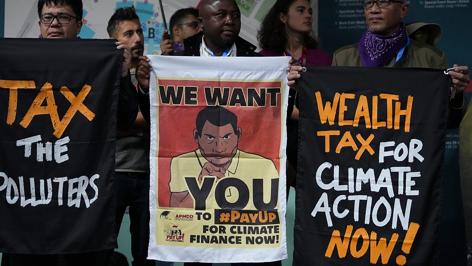 Activists participate in a demonstration for climate finance at COP29. 