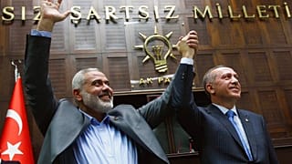O primeiro-ministro do Hamas na Faixa de Gaza, Ismail Haniyeh, à esquerda, e o seu homólogo turco, Recep Tayyip Erdogan, fazem continência no Parlamento em Ancara, Turquia, a 3 de janeiro de 2012.