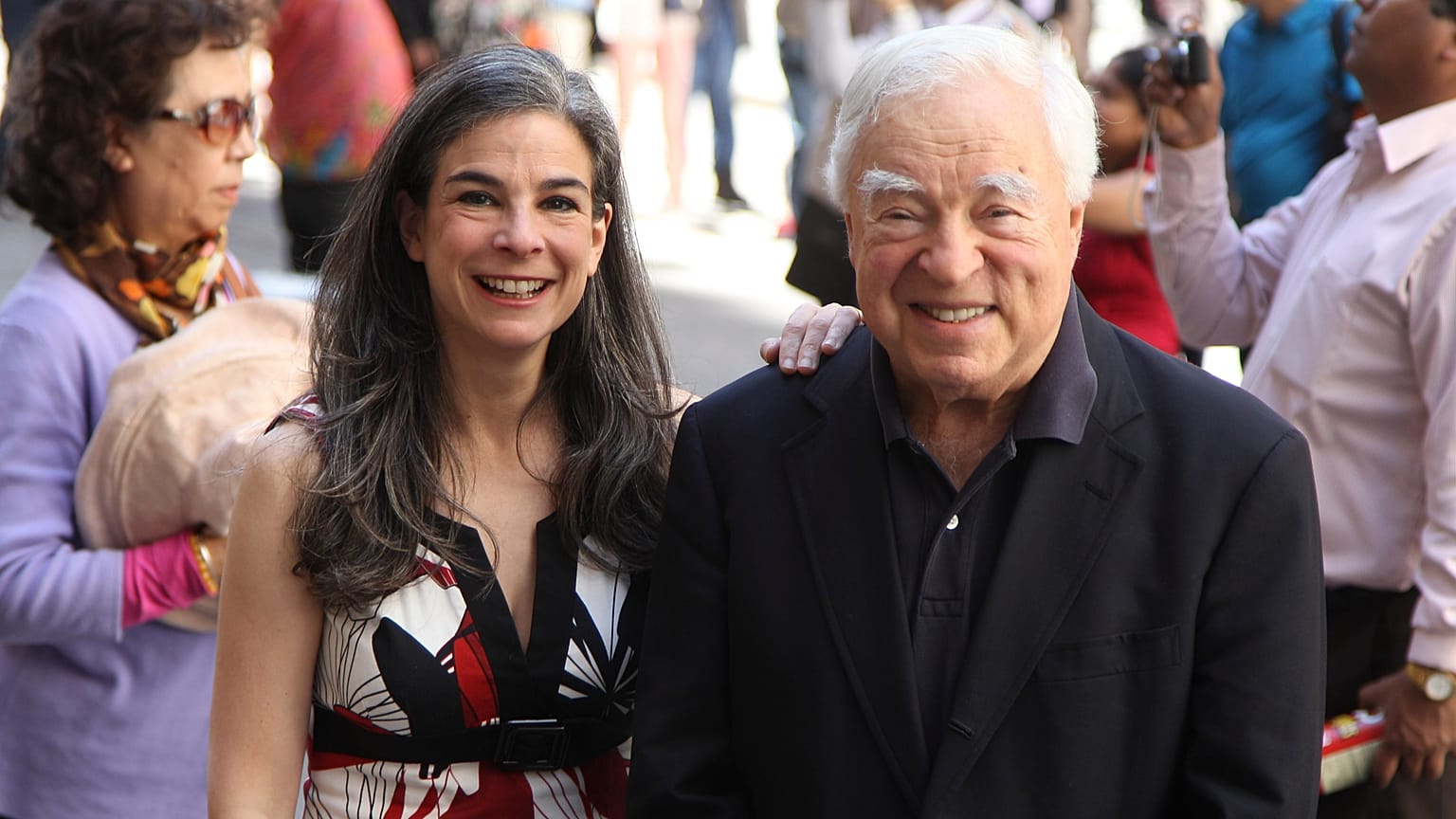 Arthur Frommer, 83, and his daughter, Pauline Frommer, 46, pose among tourists in the Wall Street area in New York, May 20, 2012. 