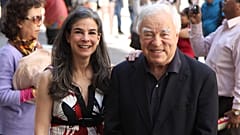 Arthur Frommer, 83, and his daughter, Pauline Frommer, 46, pose among tourists in the Wall Street area in New York, May 20, 2012. 