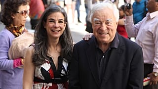 Arthur Frommer, 83, and his daughter, Pauline Frommer, 46, pose among tourists in the Wall Street area in New York, May 20, 2012. 