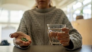 A woman prepares to take medication.