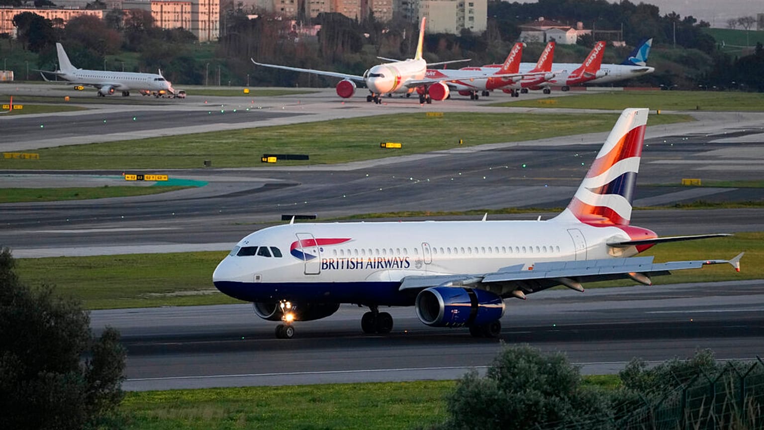 A British Airways passenger jet lands at Lisbon airport, Jan. 25, 2023.