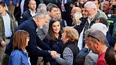 Spain's King Felipe VI speaks with a woman next to Spain's Queen Letizia, as they visit the area devastated by last month's flooding in Chiva, near Valencia, Spain