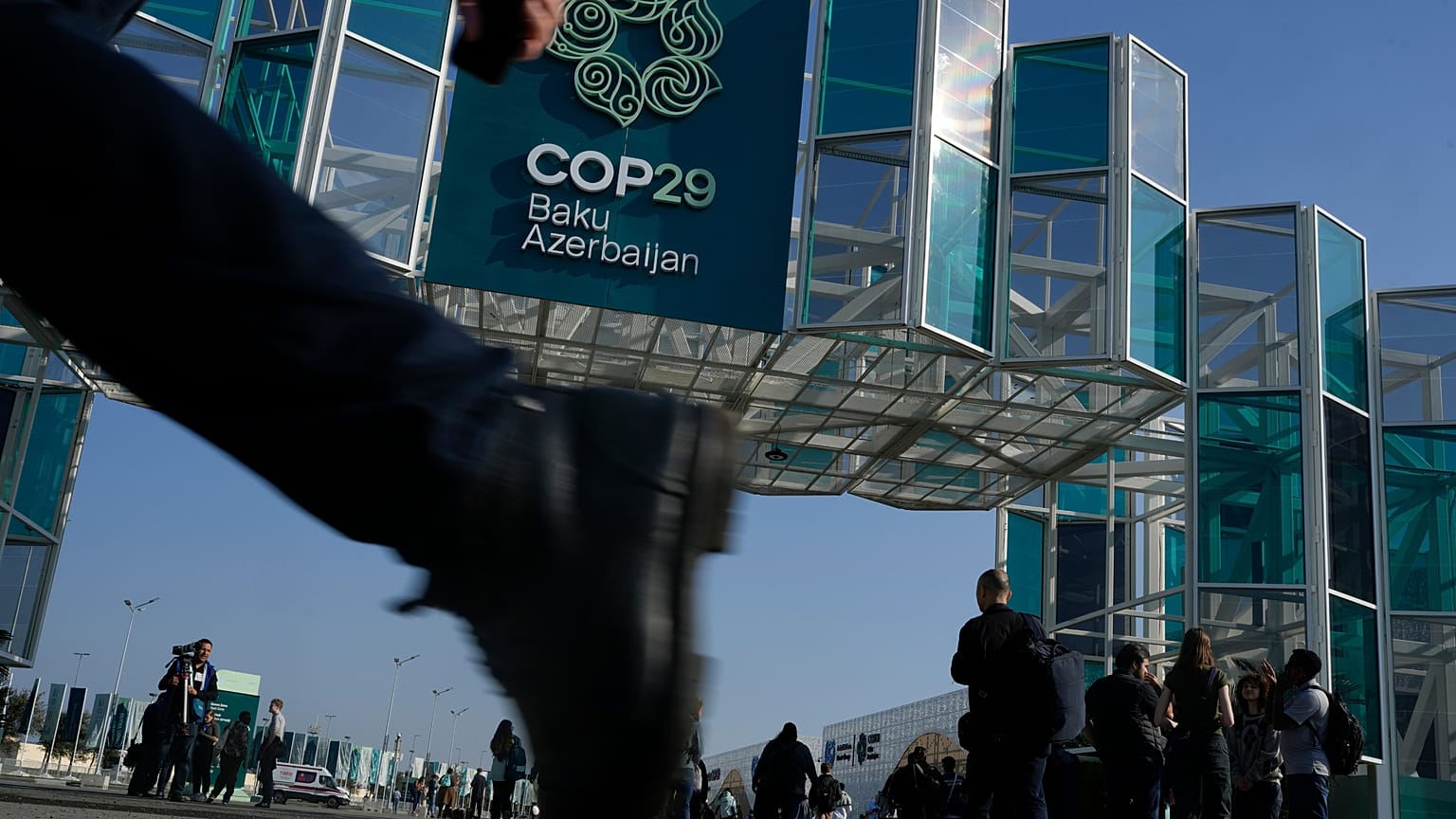 İnsanlar, Azerbaycan'ın başkenti Bakü'de, COP29'un düzenleneceği alanın dışında yürüyor. 