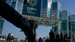 İnsanlar, Azerbaycan'ın başkenti Bakü'de, COP29'un düzenleneceği alanın dışında yürüyor. 