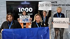 Demonstrators hold signs marking 1,000 days of war in Ukraine at COP29. 