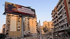 Um cartaz gigante pró-Hezbollah com palavras religiosas, colocado em frente a edifícios destruídos por ataques aéreos israelitas em Dahiyeh, no subúrbio sul de Beirute, no Líbano, na sexta-feira