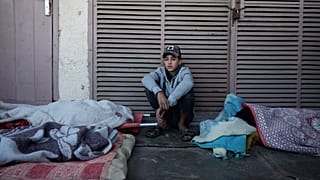 طفل فلسطيني يجلس بجانب جثث أشخاص قتلوا في غارة إسرائيلية على مخيم البريج للاجئين بقطاع غزة، الجمعة 15 نوفمبر 2024.