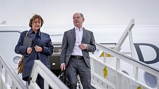 German Chancellor Olaf Scholz, right, and his wife Britta Ernst walk down the gangway of the Airbus A350 after landing at the military section of BER Berlin-Brandenburg Airpor