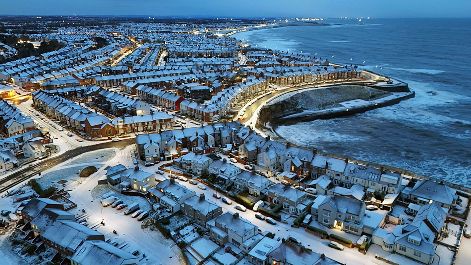 Una noche de nieve cubre la bahía de Cullercoats en North Tyneside, Reino Unido