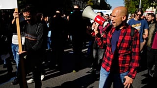 Protesters take part in rally, during a nationwide general strike organized by private and public sector unions demanding for better wages, in Athens, Wednesday, Nov. 20