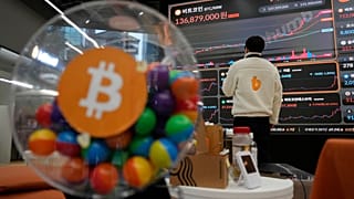 Funcionário observa painel eletrónico que exibe os preços da Bitcoin 