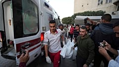 Filistinliler, Gazze'nin merkezindeki Nuseyrat'ta İsrail bombardımanı sırasında öldürülen bir kişinin cesedini taşıyor, 20 Kasım 2024