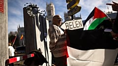 أشخاص يحملون الأعلام الفلسطينية في مدريد بجوار جدار يقولون إنه يمثل جدار الفصل الإسرائيلي احتجاجًا على زيارة الرئيس الإسرائيلي رؤوفين ريفلين وقتها إلى إسبانيا 6 نوفمبر 2017