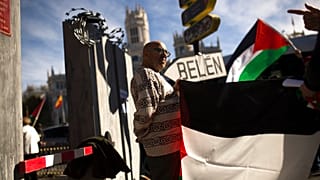 أشخاص يحملون الأعلام الفلسطينية في مدريد بجوار جدار يقولون إنه يمثل جدار الفصل الإسرائيلي احتجاجًا على زيارة الرئيس الإسرائيلي رؤوفين ريفلين وقتها إلى إسبانيا 6 نوفمبر 2017