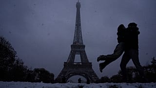 Επισκέπτες φωτογραφίζονται στο χιονισμένο Παρίσι με φόντο τον Πύργο του Άιφελ