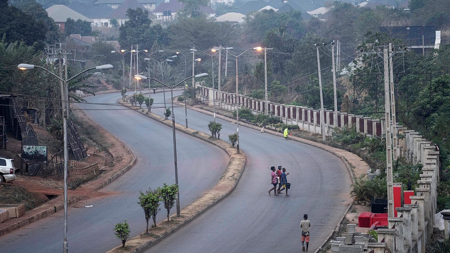 People walk across a normally packed highway during a separatists imposed lockdown in Enugu, Nigeria, 14 February 2022.