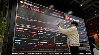 Um painel eletrónico com os preços do bitcoin e de outras criptomoedas na bolsa de criptomoedas Bithumb, em Seul.