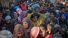 أطفال فلسطينيون يصطفون في طوابير للحصول على الطعام المتبرع به في دير البلح بقطاع غزة، الجمعة 22 نوفمبر/تشرين الثاني 2024