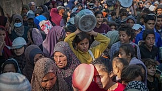 أطفال فلسطينيون يصطفون في طوابير للحصول على الطعام المتبرع به في دير البلح بقطاع غزة، الجمعة 22 نوفمبر/تشرين الثاني 2024