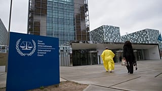 Supporters of former Ivory Coast President Laurent Gbagbo walk towards the International Criminal Court in The Hague, Netherlands, Wednesday, Jan. 16, 2019