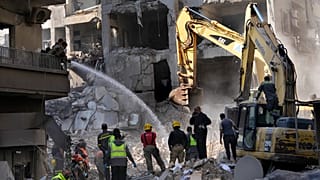 رجال الإطفاء يرشون الماء لتخفيف الغبار عن رجال الإنقاذ الذين يبحثون عن الضحايا في موقع الغارة الجوية الإسرائيلية التي ضربت وسط بيروت، السبت، 23 نوفمبر/تشرين الثاني 2024