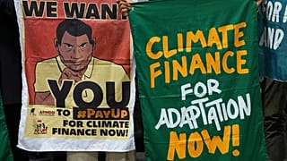 Tüntetők plakátokat tartanak a COP29 konferencián, 2024. november 23-án, az éghajlatváltozás finanszírozását követelve.