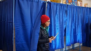 A woman prepares to cast her vote in the country's presidential elections, in Bucharest, Romania, Sunday, Nov. 24, 2024.