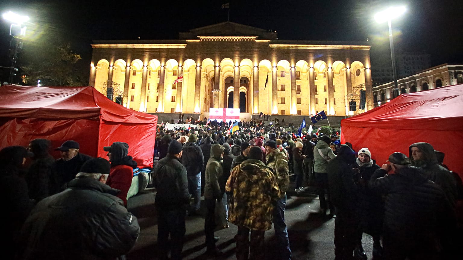 Protestujący gromadzą się przed budynkiem parlamentu w Tbilisi podczas wiecu domagającego się nowych wyborów, 24 listopada 2024 r.
