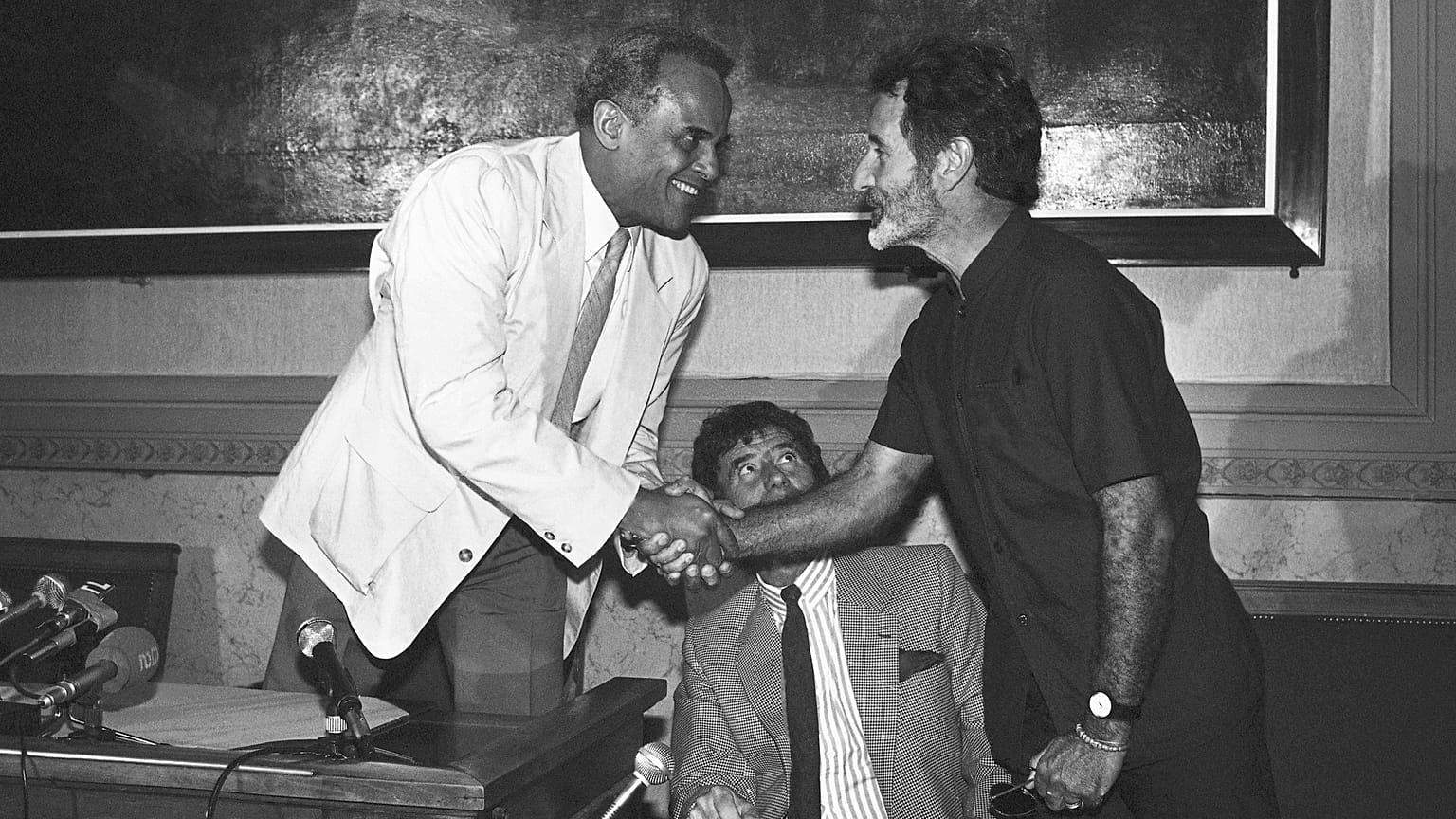 Güney Afrikalı yazar Breyten Breytenbach, sağda, Amerikalı aktör ve şarkıcı Harry Belafonte Paris'te bir basın toplantısı sırasında el sıkışıyor - Haziran 1986