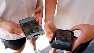 Teens use their phones to view social media in Sydney, Friday, Nov. 8, 2024.