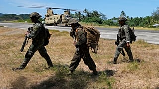 جنود فلبينيون يسيرون بجانب مروحية أمريكية من طراز CH-47 داخل القاعدة البحرية كاميلو أوسياز في بلدة سانتا آنا، مقاطعة كاغايان، شمال الفلبين يوم الاثنين، 6 أيار/مايو 2024