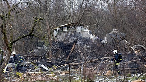 Lithuanian ministry employees, emergency workers and police stand near the spot where the DHL cargo plane crashed Vilnius, Lithuania, 25.11.2024
