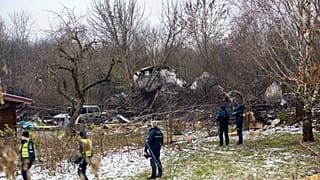 Mitarbeiter des litauischen Ministeriums, Notärzte und Polizisten stehen in der Nähe der Stelle, an der das DHL-Frachtflugzeug abgestürzt ist Vilnius, Litauen, 25.11.2024