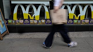 Una mujer pasa junto a un restaurante McDonald's en Londres en 2021.