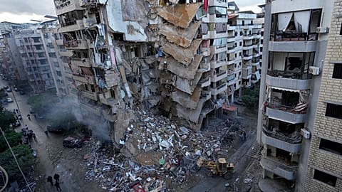 Des bulldozers enlèvent les décombres d'un bâtiment détruit dimanche soir par une frappe aérienne israélienne à Dahiyeh, banlieue sud de Beyrouth, au Liban, le 25.11.2024