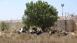 مهاجرون يتجمعون في منطقة صحراوية على الجانب الليبي من الحدود التونسية الليبية 23 تموز يوليو 2023
