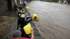 Pessoas a socorrerem-se para evitar que a água chegue às suas casas. Pontypridd, Reino Unido em 24.11.2024