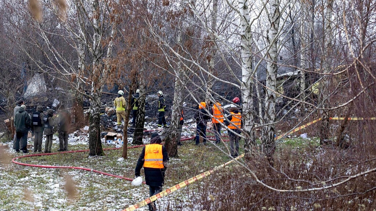 Mitarbeiter des litauischen Katastrophenschutzministeriums arbeiten an der Unglücksstelle, nachdem ein DHL-Frachtflugzeug in ein Haus in der Nähe von Vilnius, Litauen, gestürzt ist, Montag, 25. November 2024.