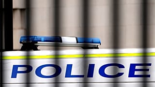 A police van is parked behind railings in Westminster in London, Tuesday, March 21, 2023.