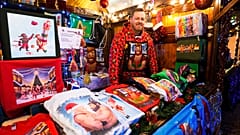 Artist Paul Middleton stands in his shop with shirts he designed at the LGBTQ+ Christmas market "Christmas Avenue" at Nollendorfplatz the for in Berlin. 