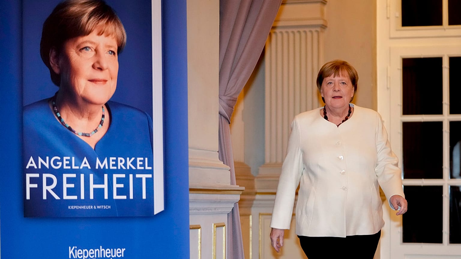 Angela Merkel posa junto a un cartel con su libro.