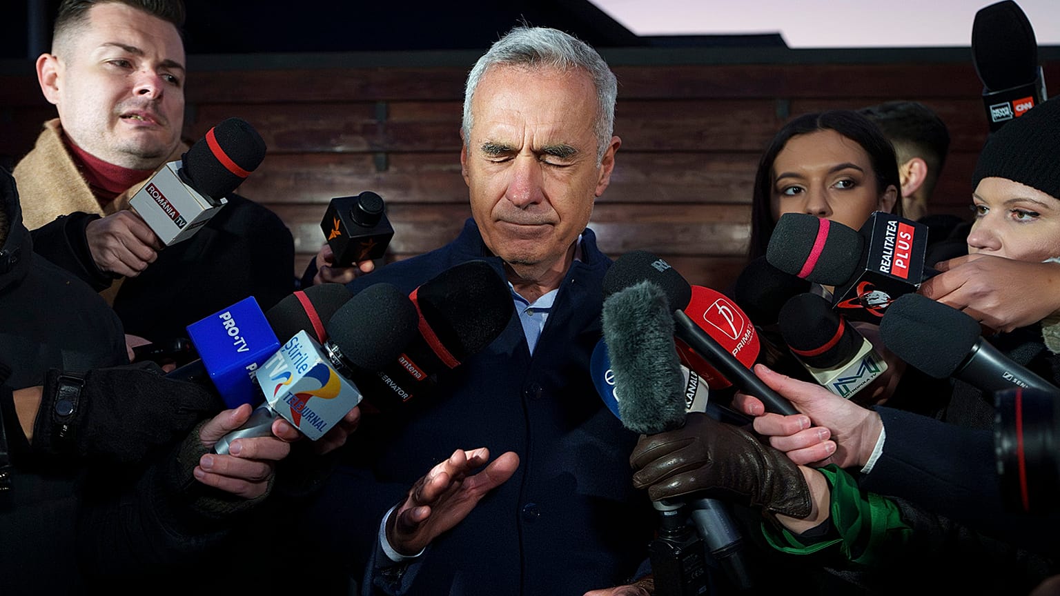 Calin Georgescu, candidato indipendente alla presidenza, si tocca il viso mentre parla con i media, a Izvorani, 26 novembre 2024