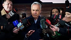 Calin Georgescu, candidato independente à presidência, toca no rosto enquanto fala à comunicação social, em Izvorani, 26 de novembro de 2024