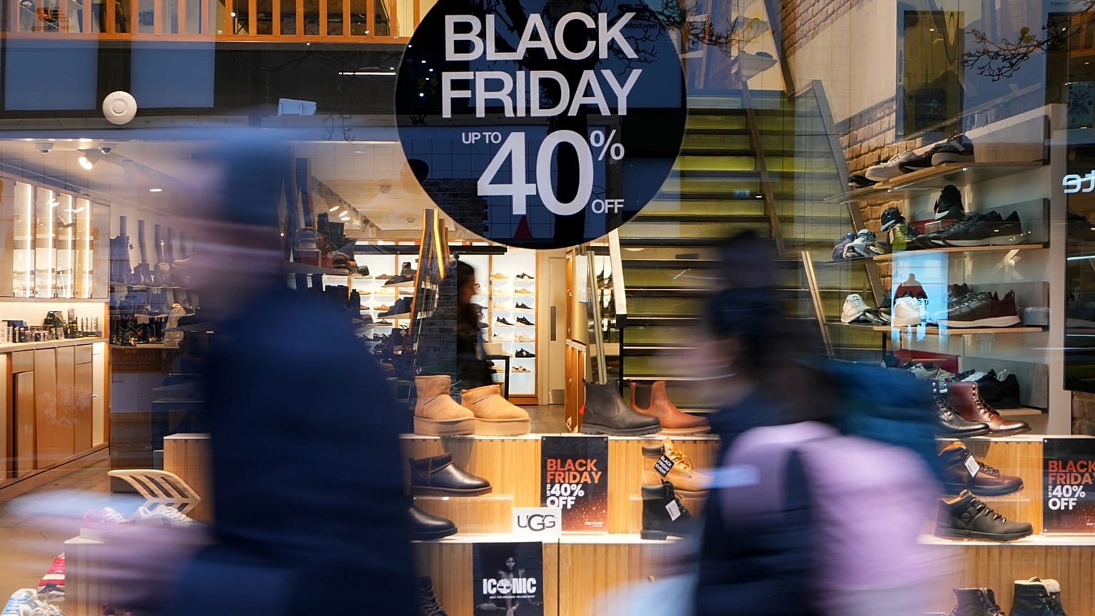 İnsanlar 27 Kasım 2024 Çarşamba günü Londra'daki Oxford Caddesi'nde Kara Cuma İndirimi reklamı yapan bir mağazanın önünden geçiyor. (AP Fotoğrafı/Kirsty Wigglesworth)