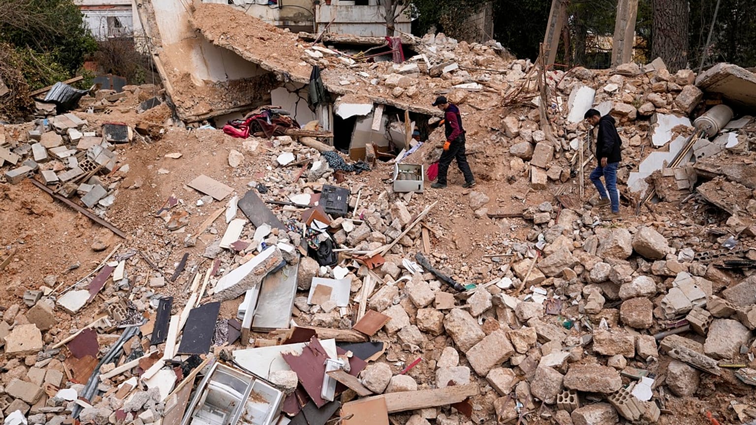 نازحون يمشون على أنقاض منزلهم المدمر في بعلبك، شرق لبنان، الخميس، 28 نوفمبر/تشرين الثاني 2024.